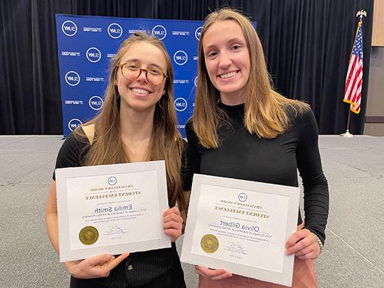 two women holding certificates